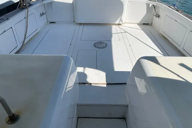 Slide: The Image of 1979 Bertram 31 Flybridge Cruiser deck with white seating and storage compartments. - 17