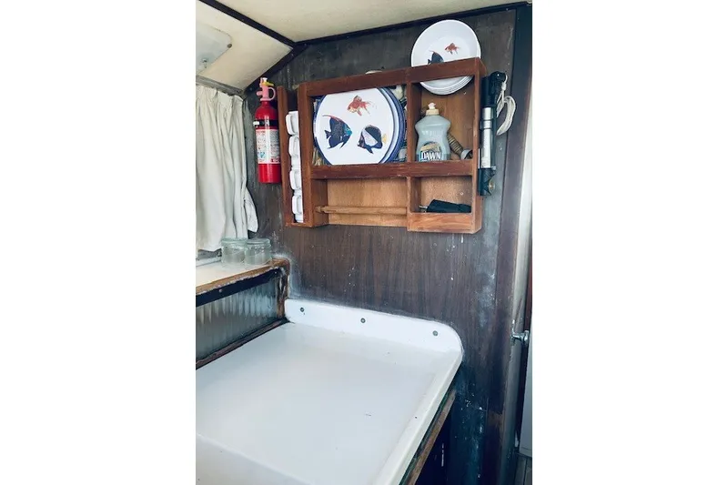 Slide: The Image of Interior of 1979 Bertram 31 Flybridge Cruiser with kitchen shelf and fire extinguisher. - 9