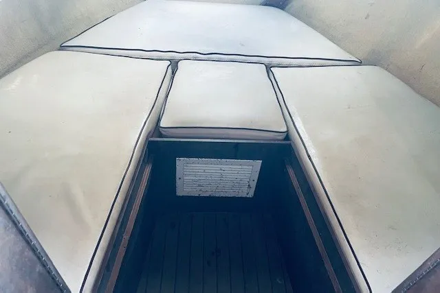 Slide: The Image of Interior cabin view of a 1979 Bertram 31 Flybridge Cruiser with cushioned seating. - 13