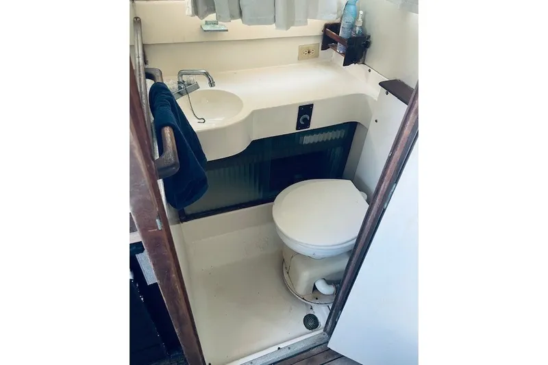 Slide: The Image of 1979 Bertram 31 Flybridge Cruiser bathroom with sink, toilet, and towel. - 7