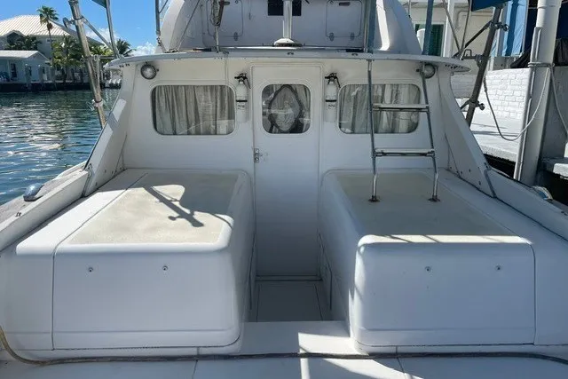 Slide: The Image of 1979 Bertram 31 Flybridge Cruiser, rear view, docked by waterfront homes. - 16