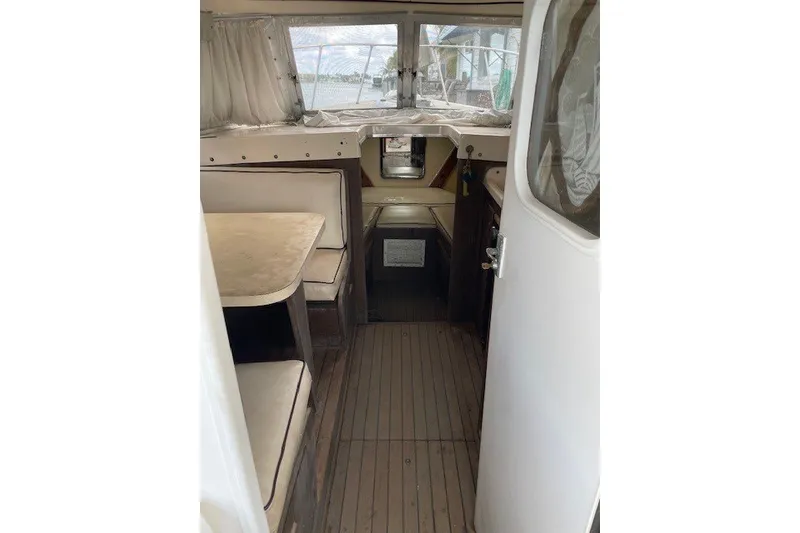 Slide: The Image of Interior of a 1979 Bertram 31 Flybridge Cruiser with seating and wooden flooring. - 3