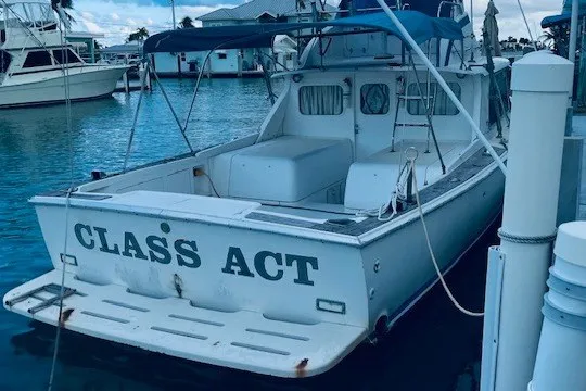 Slide: The Image of 1979 Bertram 31 Flybridge Cruiser docked, named "Class Act," in a marina setting. - 15