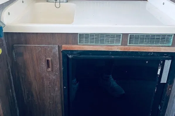 Slide: The Image of 1979 Bertram 31 Flybridge Cruiser interior with sink and storage cabinet. - 8