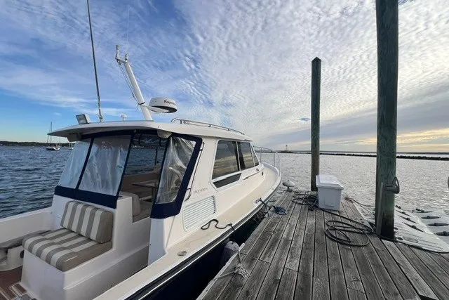 Slide: The Image of 2008 True North 34 boat docked by a wooden pier under a cloudy sky. - 4