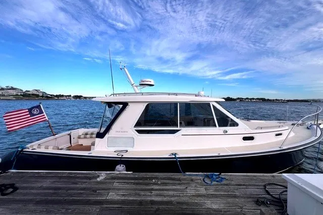 The Image of 2008 True North 34 boat docked by the ocean under a clear blue sky. - 0