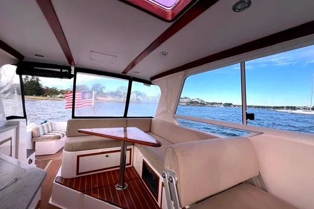 Slide: The Image of Interior of 2008 True North 34 boat with seating, table, and scenic water view. - 10