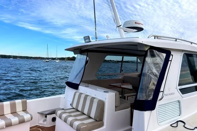 Slide: The Image of 2008 True North 34 boat on water, featuring striped seating and Raymarine equipment. - 3