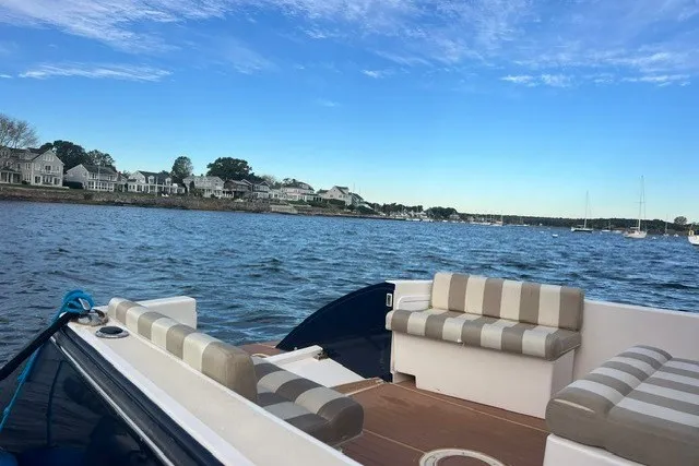 Slide: The Image of True North 34 boat, 2008 model, with striped seating on a calm waterfront. - 9