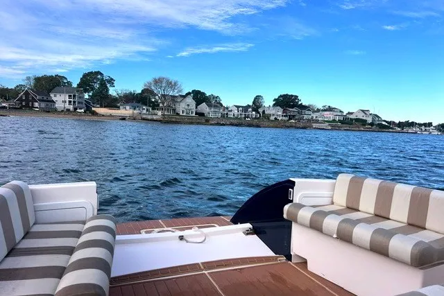 Slide: The Image of True North 34 boat, 2008 model, with striped seating, cruising near coastal homes. - 8