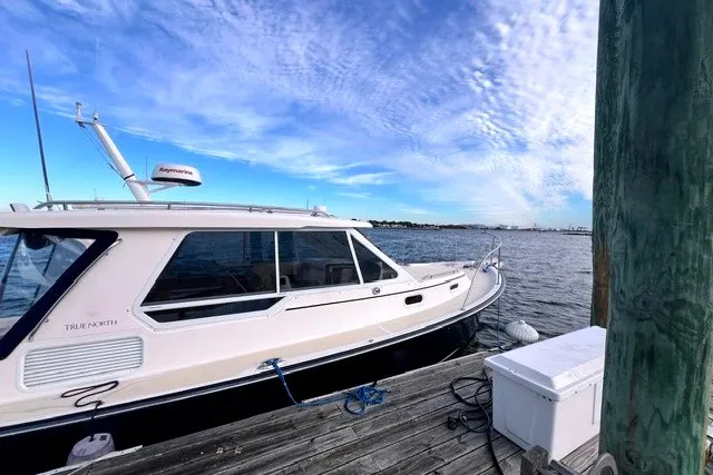 Slide: The Image of 2008 True North 34 boat docked by the water under a blue sky. - 1