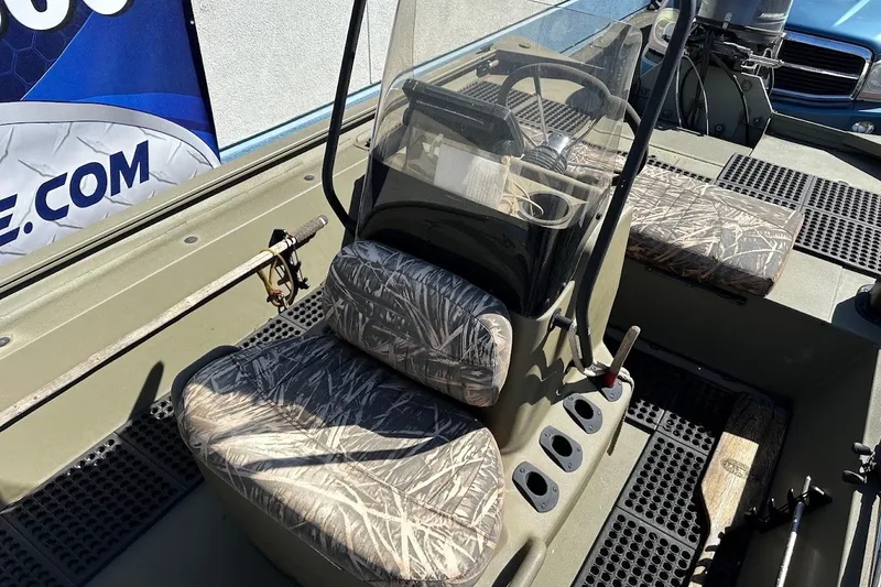 Slide: The Image of 2017 Tracker Grizzly 1860 MVX CC boat interior with camouflage seats and steering console. - 13