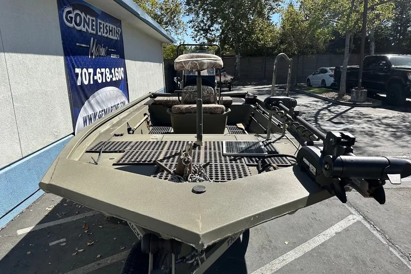 Slide: The Image of 2017 Tracker Grizzly 1860 MVX CC boat parked outdoors near a fishing store. - 18