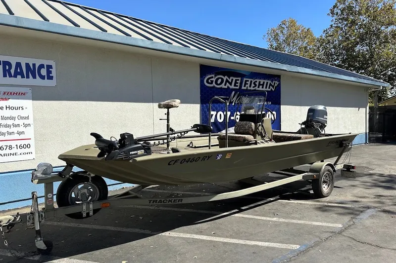 Slide: The Image of 2017 Tracker Grizzly 1860 MVX CC boat on trailer outside a marine store. - 16