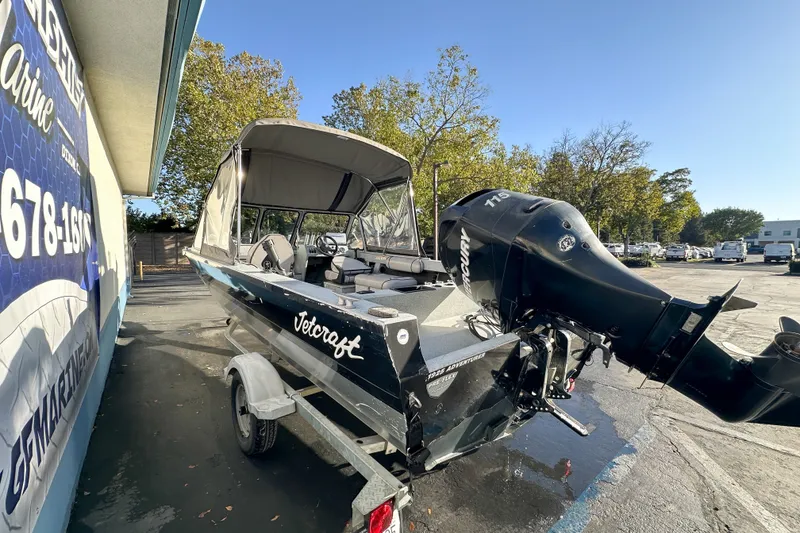 Slide: The Image of 2008 Jetcraft 1925 Adventurer boat with Mercury engine, parked outdoors on a sunny day. - 2