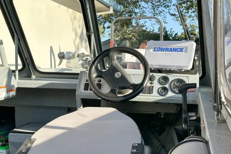 Slide: The Image of Interior of 2008 Jetcraft 1925 Adventurer boat with steering wheel and Lowrance navigation system. - 7