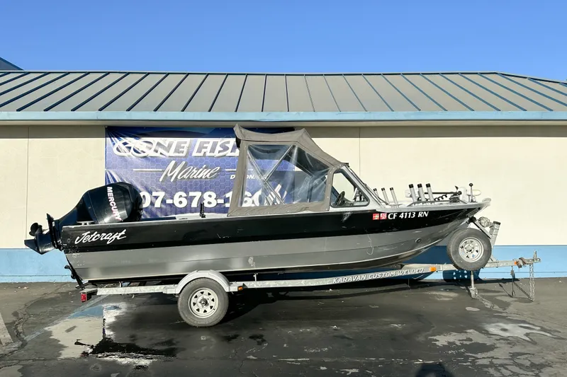 The Image of 2008 Jetcraft 1925 Adventurer boat on trailer, parked outside a marine shop. - 0