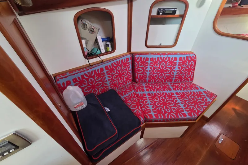 Slide: The Image of Cozy seating area in 1998 Able Wolf Class 36 boat with vibrant red cushions. - 29