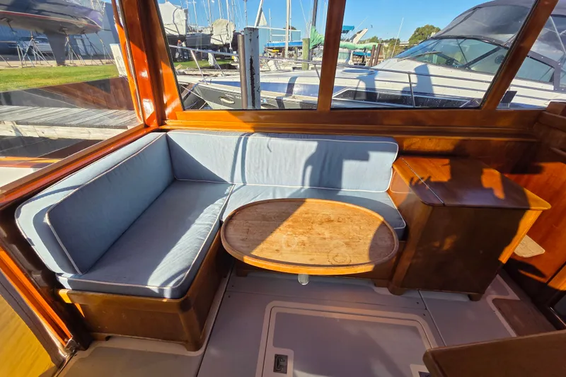 Slide: The Image of Cozy seating area on 1998 Able Wolf Class 36 yacht with wooden table and blue cushions. - 19