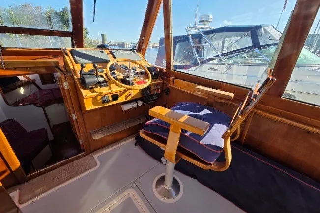 Slide: The Image of Interior of 1998 Able Wolf Class 36 boat with wooden helm and cushioned seating. - 18