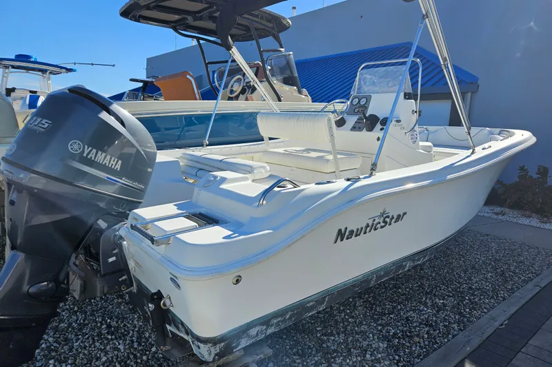 The Image of 2013 NauticStar 1900XS Offshore boat with Yamaha 115 engine, docked outdoors. - 0
