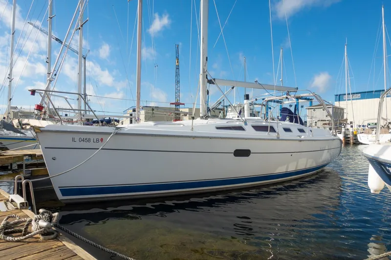 The Image of 2003 Hunter 356 sailboat docked at marina under clear blue sky. - 0