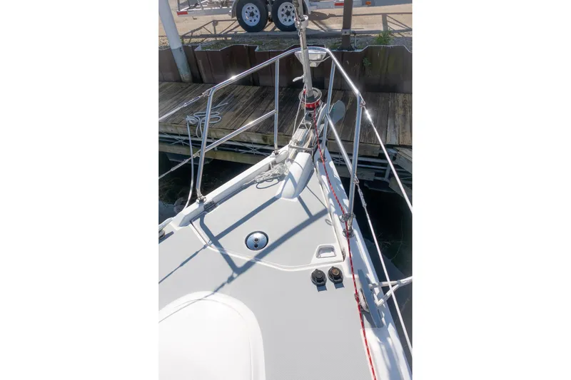 Slide: The Image of Bow of 2003 Hunter 356 sailboat docked, featuring deck fittings and railing. - 7