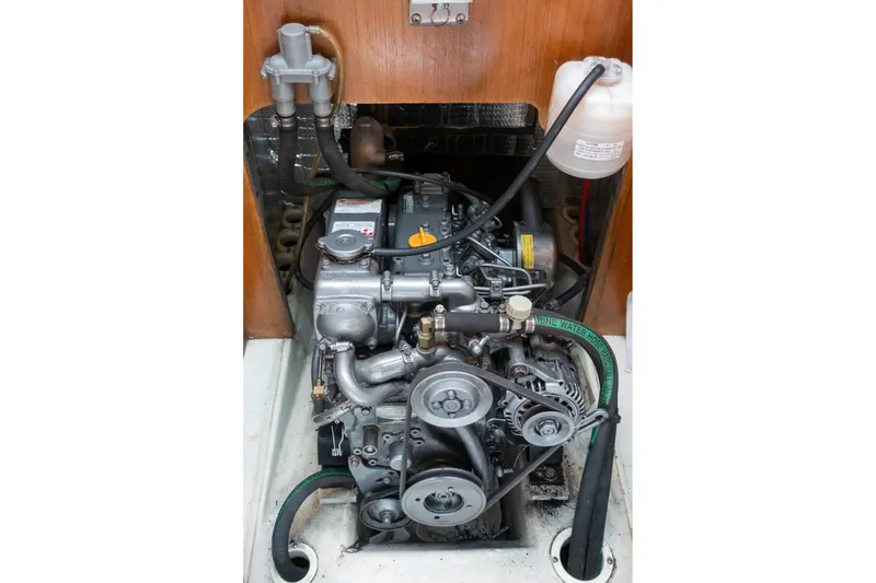 Slide: The Image of Engine compartment of a 2003 Hunter 356 sailboat, showcasing mechanical components and hoses. - 17
