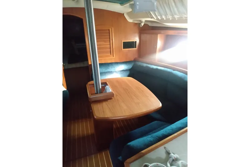 Slide: The Image of Interior of 2003 Hunter 356 sailboat with wooden table and blue cushioned seating. - 13