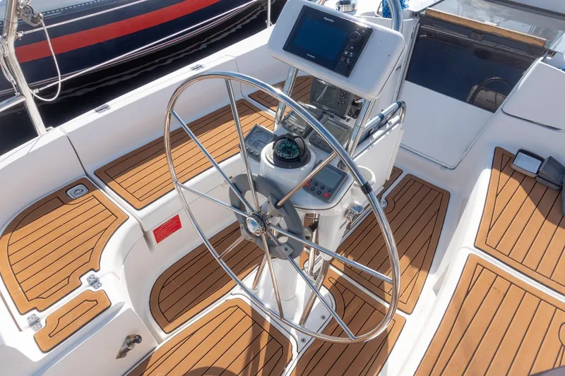 Slide: The Image of Steering wheel and controls of a 2003 Hunter 356 sailboat with teak flooring. - 5