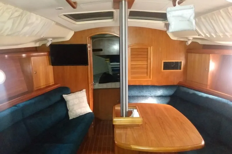 Slide: The Image of Interior of 2003 Hunter 356 sailboat with wooden furnishings and blue seating. - 11