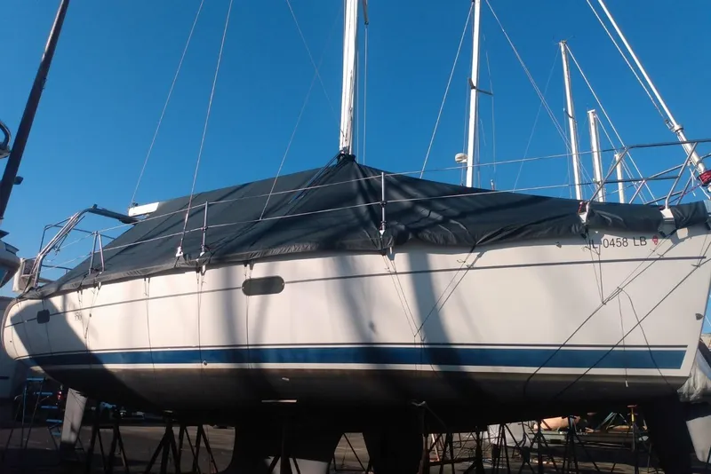 Slide: The Image of 2003 Hunter 356 sailboat on stands, covered, with clear blue sky background. - 10