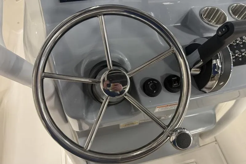 Slide: The Image of Steering wheel and controls of 2025 Bayliner Trophy T24CC boat. - 14