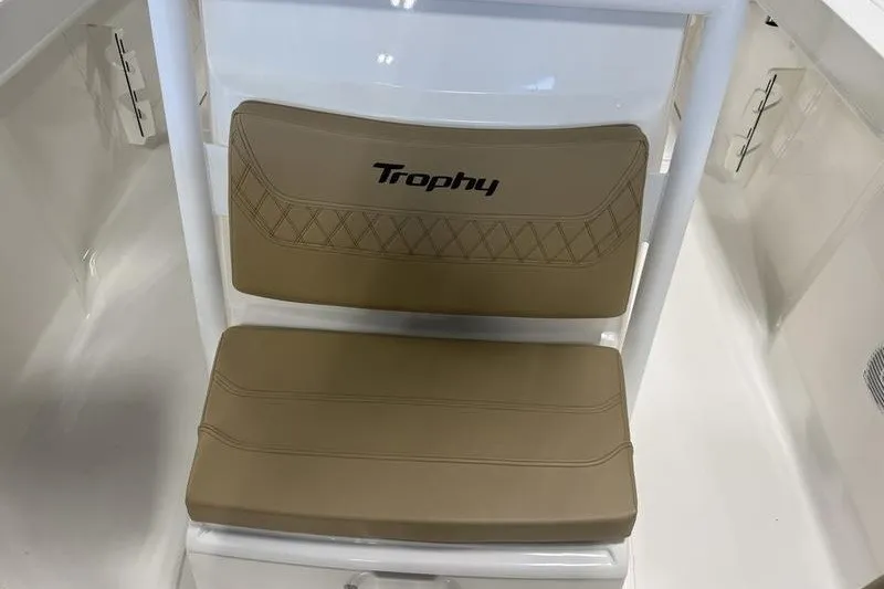 Slide: The Image of 2025 Bayliner Trophy T24CC boat seat with beige cushions and "Trophy" logo. - 16
