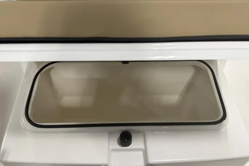 Slide: The Image of 2025 Bayliner Trophy T24CC storage compartment, open with beige interior and black trim. - 17