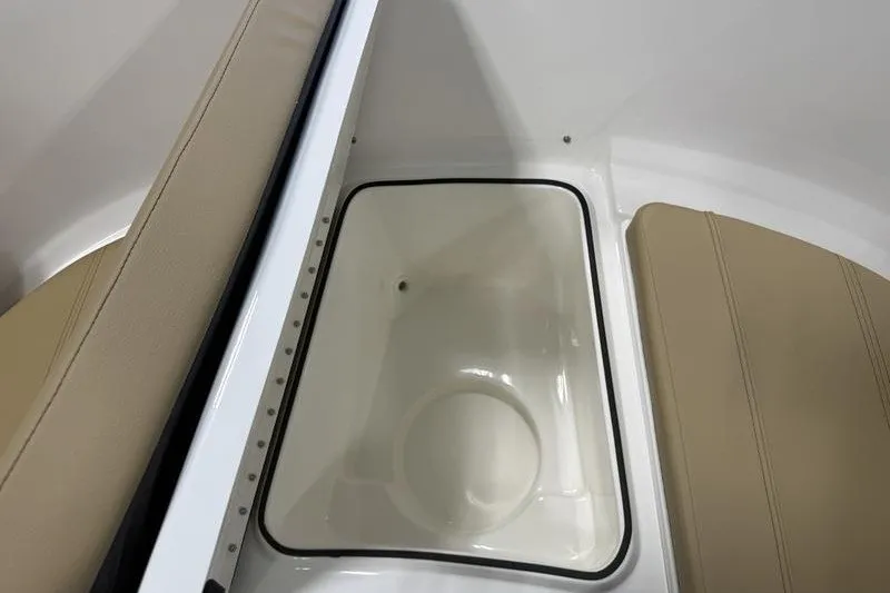Slide: The Image of 2025 Bayliner Trophy T24CC boat interior with beige seating and storage compartment. - 20