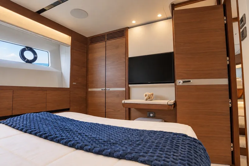 Slide: The Image of Luxurious 2021 Princess Y85 yacht bedroom with wood paneling and modern decor. - 54