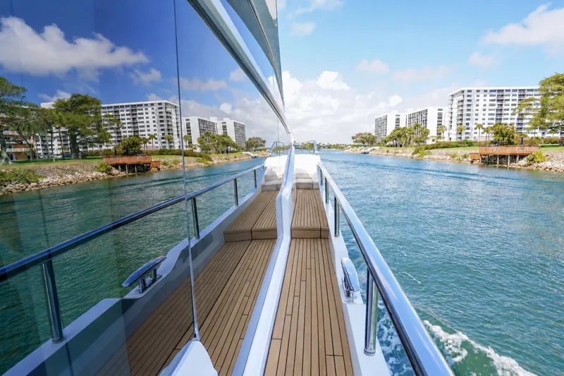 Slide: The Image of Luxurious 2021 Princess Y85 yacht cruising along a scenic waterfront with modern buildings. - 11