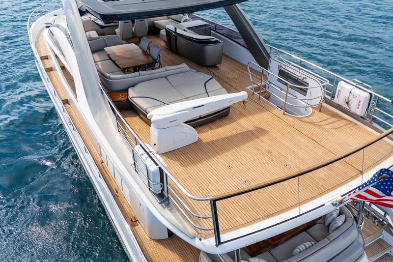 Slide: The Image of Das Bild zeigt das Deck einer luxuriösen Yacht mit Liegeflächen und einem Esstisch. - 7