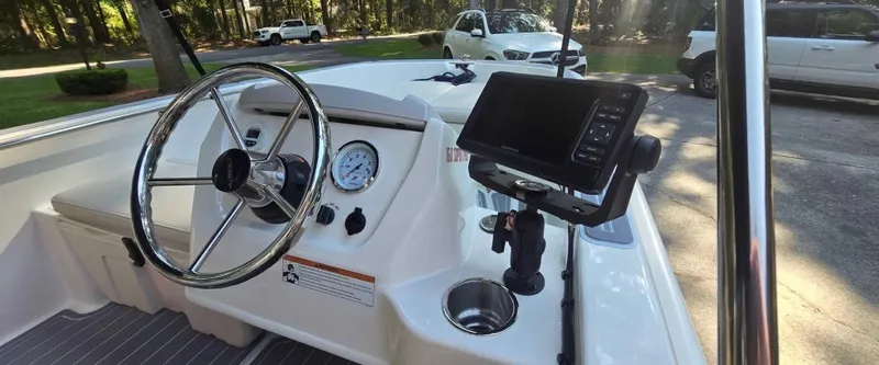 Slide: The Image of The image shows the cockpit of a 2021 Boston Whaler 160 Super Sport with steering wheel and instruments. - 2