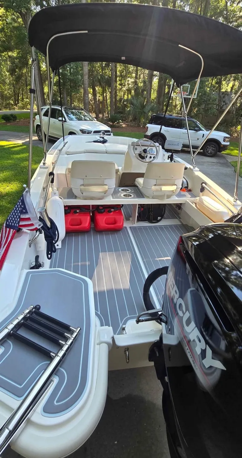 Slide: The Image of 2021 Boston Whaler 160 Super Sport with open deck, seating, and outboard motor. - 5