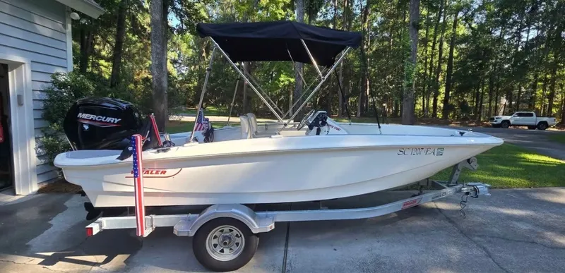 Slide: The Image of A 2021 Boston Whaler 160 Super Sport on a trailer in a driveway. - 1
