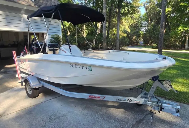 Slide: The Image of A 2021 Boston Whaler 160 Super Sport sits on a trailer in a driveway. - 0