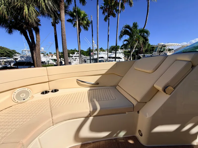 Slide: The Image of Interior of a 2019 Chris-Craft Launch 28 GT OB with beige upholstery and palm trees in the background. - 36