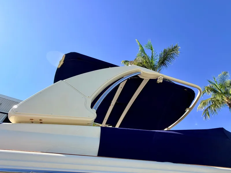 Slide: The Image of A sunshade on a 2019 Chris-Craft Launch 28 GT OB, with palm trees in the background. - 20