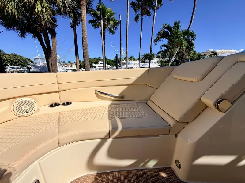 Slide: The Image of Interior of a 2019 Chris-Craft Launch 28 GT OB with beige upholstery and palm trees in the background. - 31