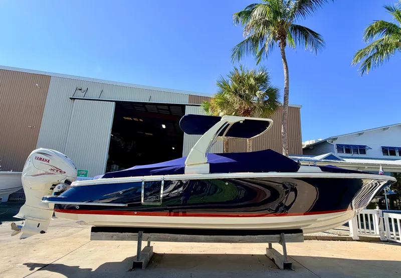 Slide: The Image of 2019 Chris-Craft Launch 28 GT OB in a boatyard, featuring a blue hull and Yamaha outboard motor. - 13
