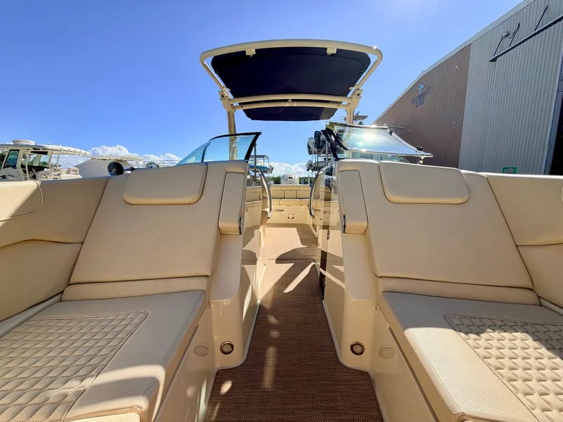 Slide: The Image of The image shows the cockpit of a 2019 Chris-Craft Launch 28 GT OB with beige seating. - 33