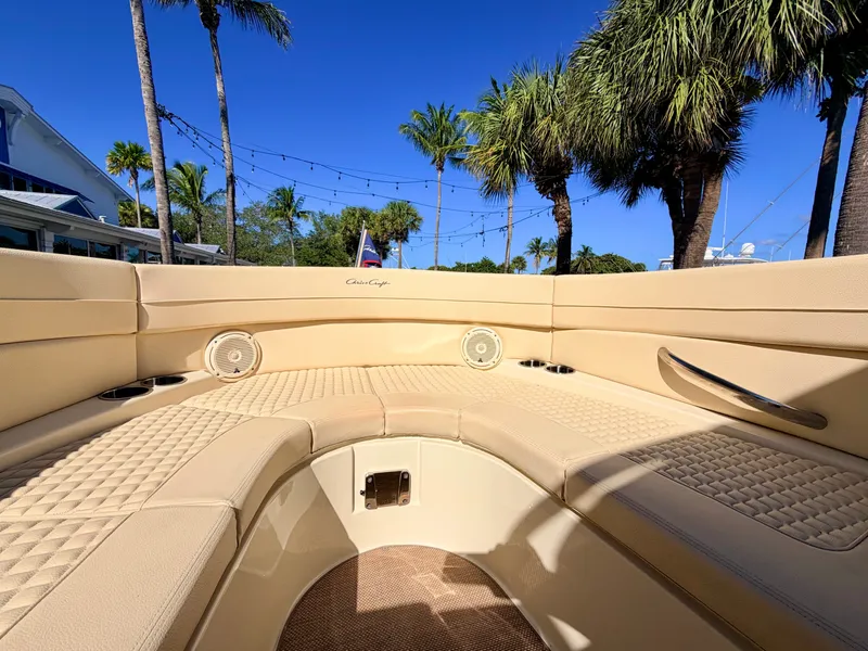 Slide: The Image of Interior view of a 2019 Chris-Craft Launch 28 GT OB with beige upholstery and palm trees in the background. - 39