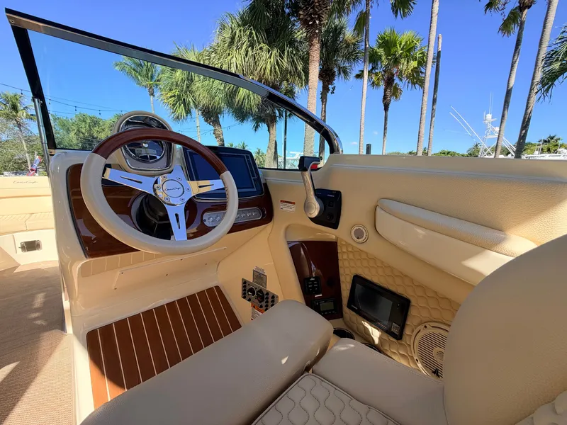 Slide: The Image of The cockpit of the 2019 Chris-Craft Launch 28 GT OB features a sleek steering wheel and modern instruments. - 47